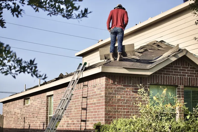 Professional roofer working on a residential roof in Oak Point